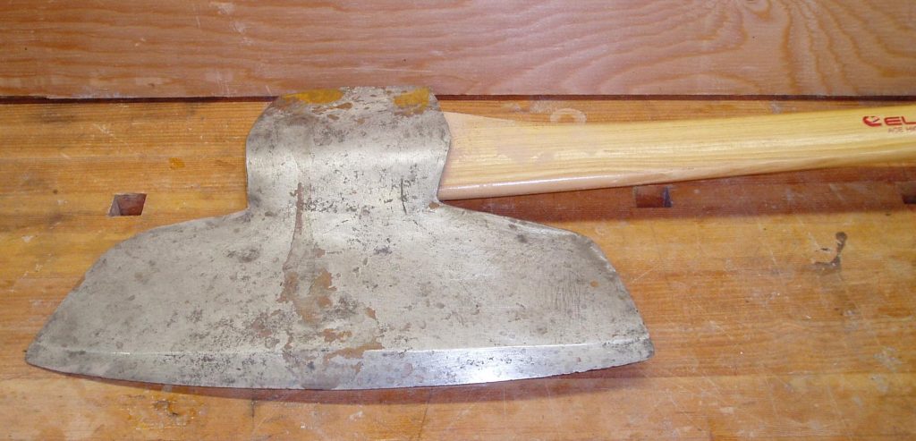 Broadaxe head on wooden surface – traditional timber hewing tool for squaring logs into beams