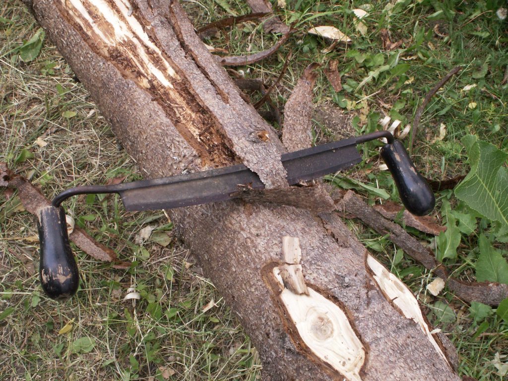 Craftsman using drawknife at Hessenpark open-air museum – traditional woodworking demonstration