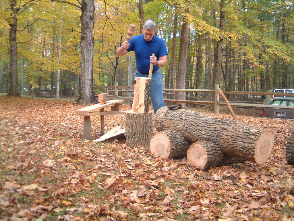 Craftsman using froe for shingle making – traditional woodworking demonstration at Civilian Conservation Corps event