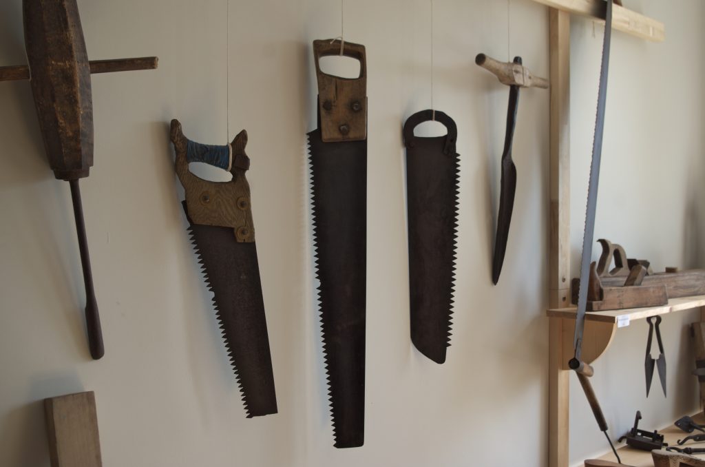 Collection of traditional handsaws on wall – pre-industrial woodworking saws in Estonian folk museum