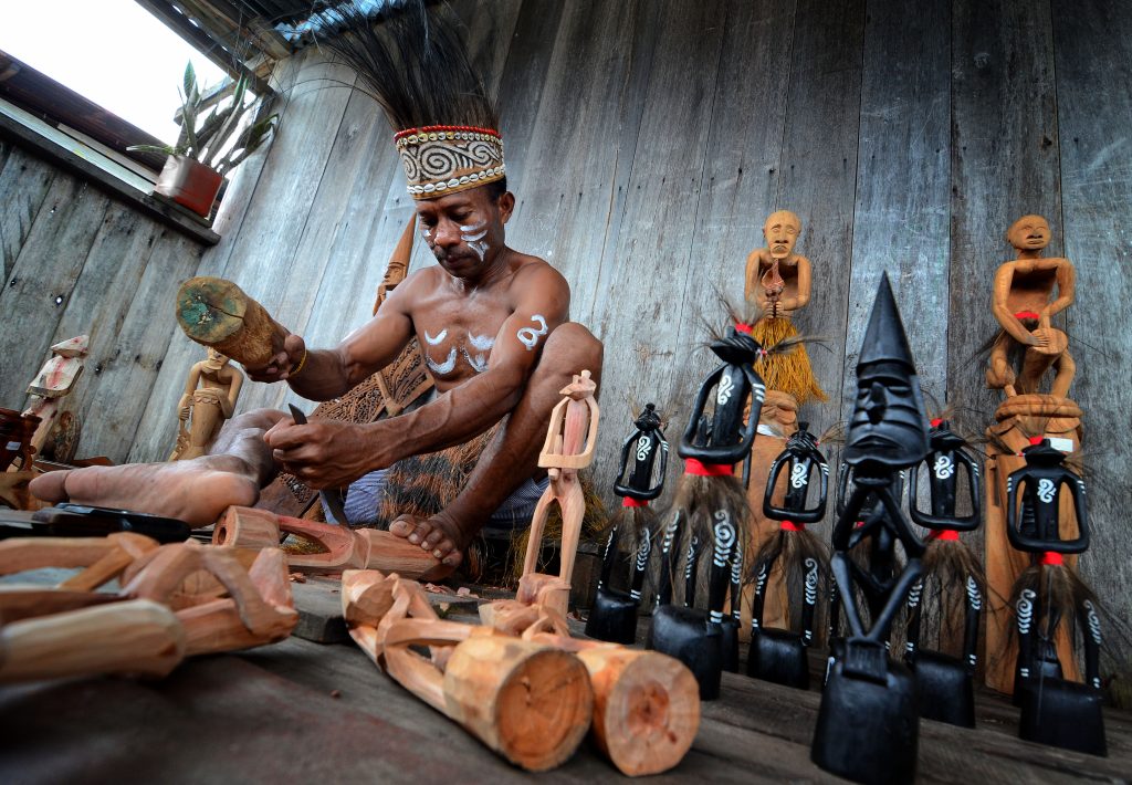 Chisel in use – craftsman carving an Asmat figure using a hand chisel