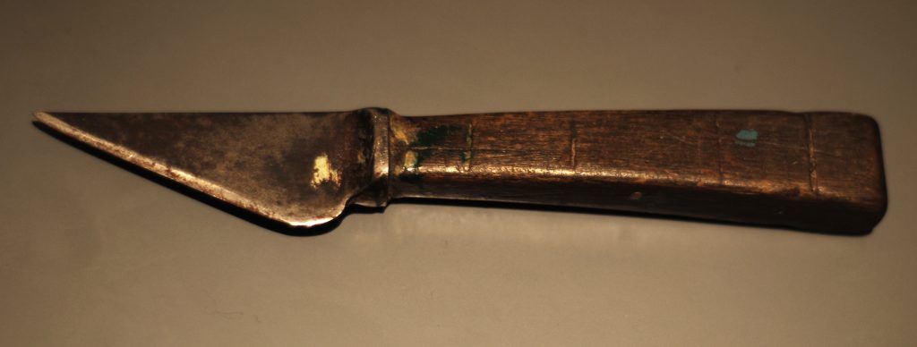 Marking knife in use, scribing a layout line along a wooden workpiece