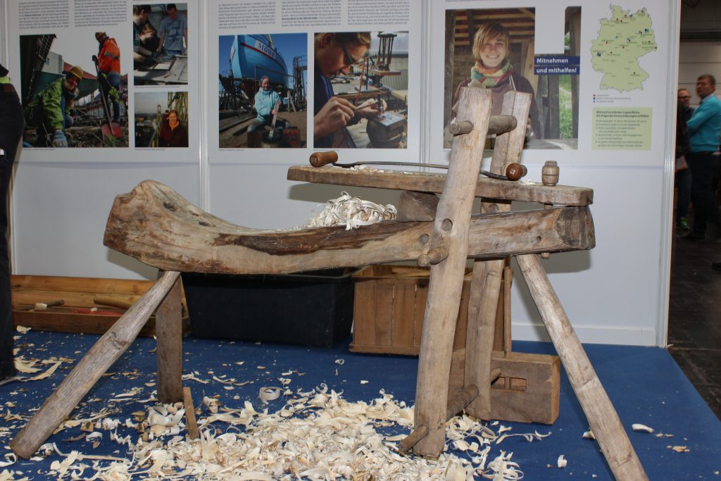 Craftsman using shaving horse at heritage fair – traditional woodworking workbench demonstration